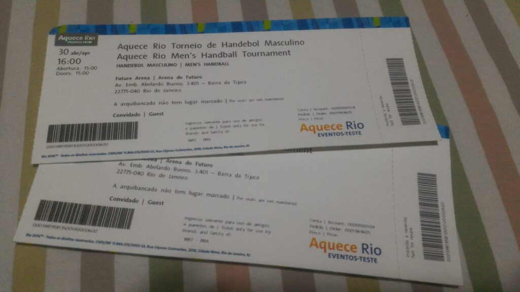 Photograph of two official printed tickets for the "Aquece Rio Men's Handball Tournament". The tickets are for April 30th at 4:00 PM at Arena do Futuro, in Barra da Tijuca. They are printed with the category "Guest" and have the logo "Aquece Rio EVENTOS-TESTE".