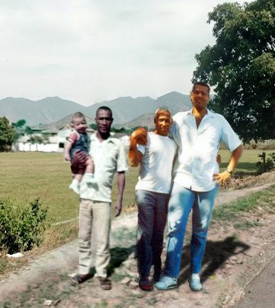 Montagem fotográfica lado a lado comparando o crescimento de GeovaneSou. À esquerda (1973), Geovane bebê no colo de seu pai de estatura mediana. À direita (1994), Geovane adulto e gigante, com 2,07m, abraçado ao mesmo pai, destacando o contraste impressionante de altura e a narrativa dos "Genes de Dinossauro".